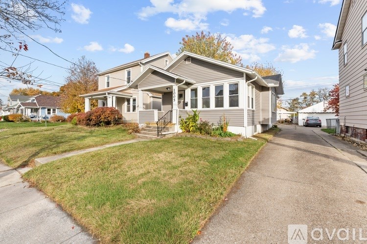 A house with a grey roof and a white garage door is for sale.