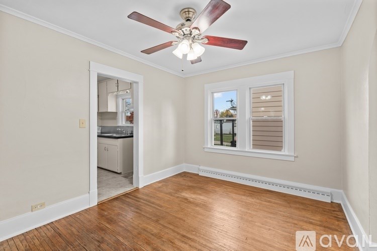 A room with a ceiling fan and a window with blinds.