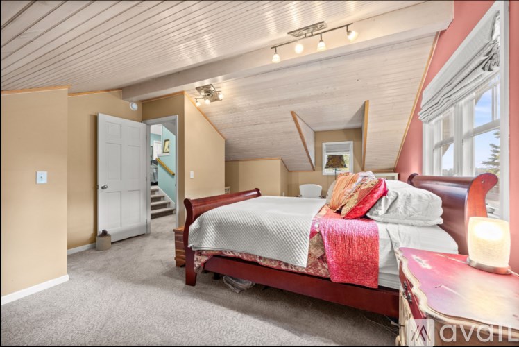A bedroom with a bed, a dresser, and a window.