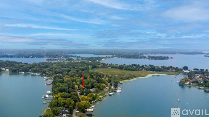 A red flag is flying in front of a body of water.