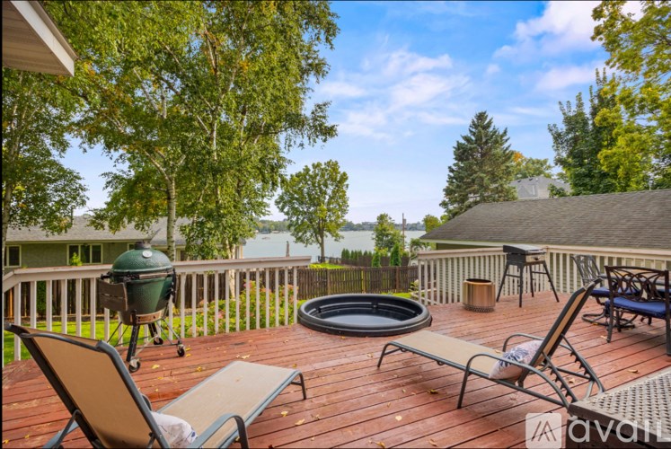 A wooden deck with a grill and chairs.