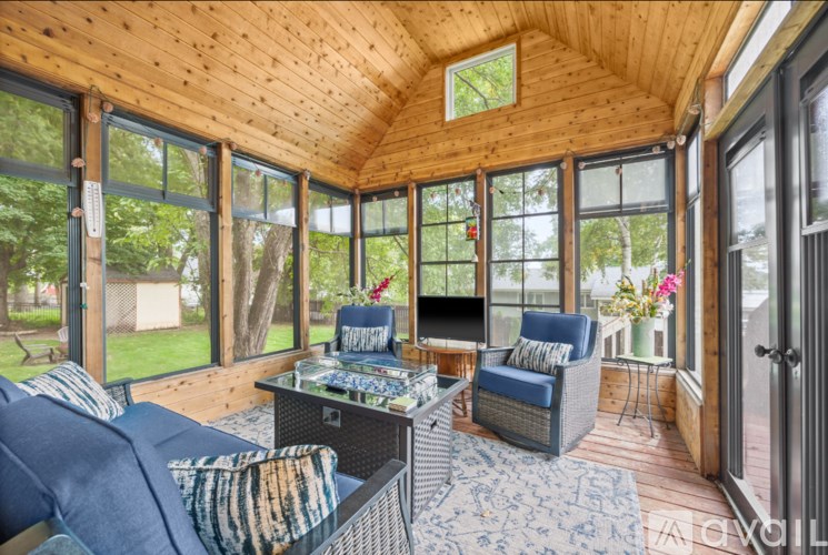 A sunroom with a blue couch and a coffee table.