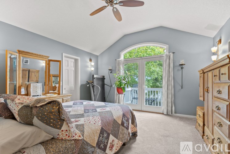 A bedroom with a bed, dresser, mirror, and window.