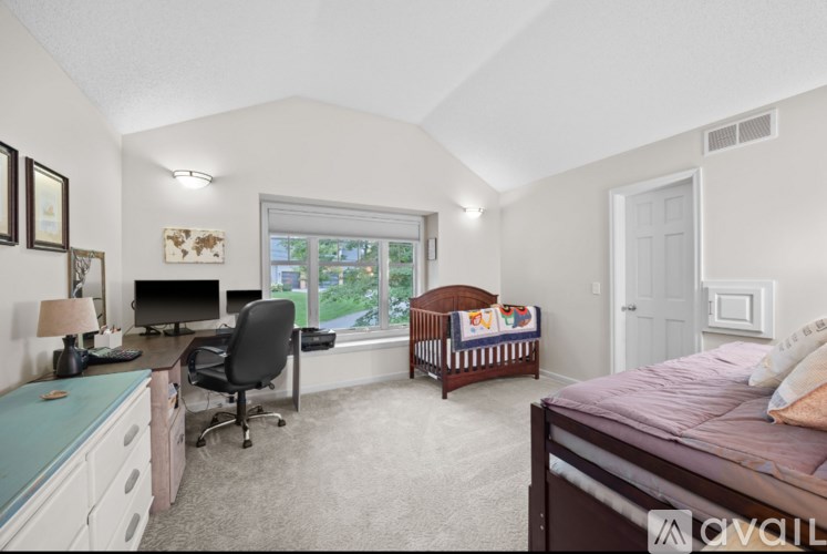 A bedroom with a bed, desk, and chair.