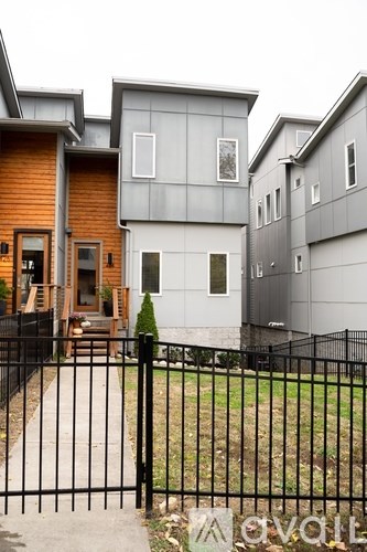 A modern house with a black fence in front.