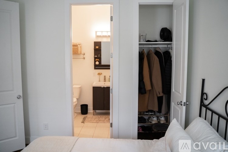 A bedroom with a bed, a closet, and a bathroom visible through the door.