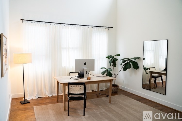 A room with a desk, chair, and a mirror.