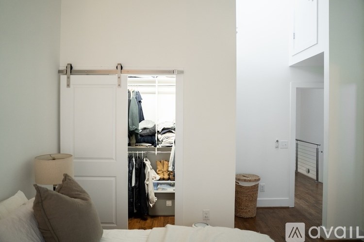 A bedroom with a bed, a lamp, a closet, and a window.