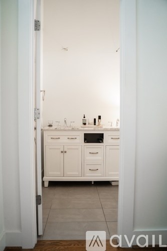 A white kitchen with a sink and cabinets.