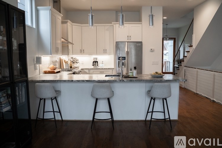 A modern kitchen with a bar area and stools.