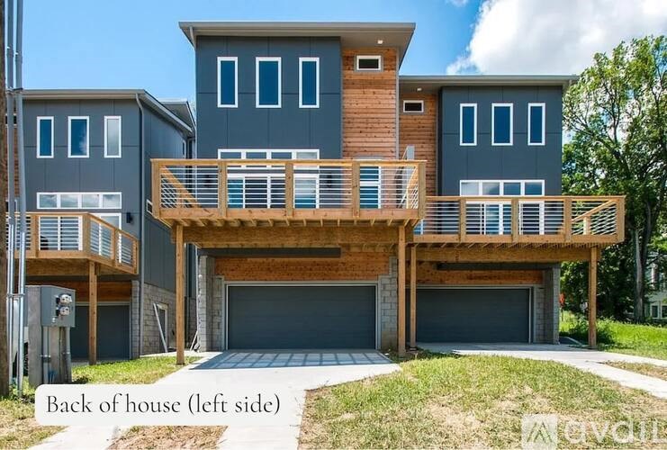 A modern house with a wooden deck and a garage.
