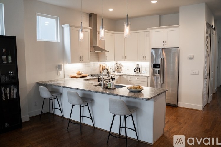 A modern kitchen with a large island and stools.