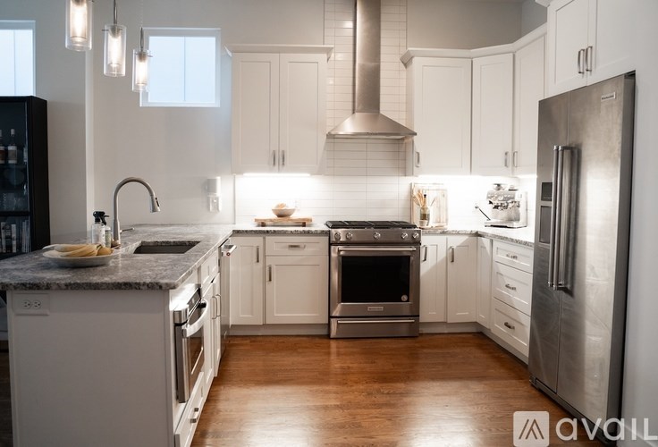 A modern kitchen with white cabinets and stainless steel appliances.