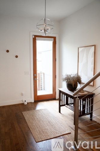 A room with a wooden floor and a brown rug.