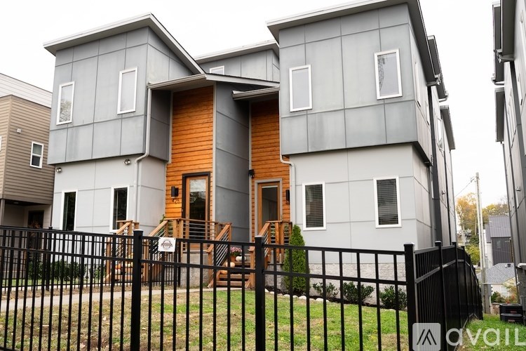 A modern house with a black fence in front.