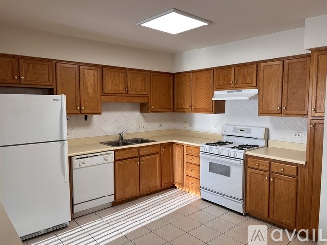 A kitchen with wooden cabinets and white appliances.