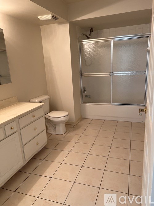 A bathroom with a toilet, sink, and shower.