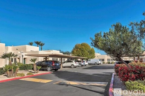 A parking lot with cars and a building in the background.