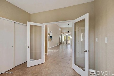 A hallway with a glass door and a mirror on the wall.