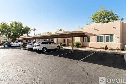 A parking lot with cars and a building in the background.