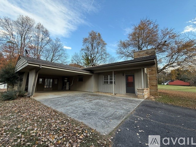 A house with a grey roof and a brick chimney is available for rent.