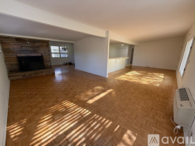A spacious living room with a fireplace and hardwood flooring.