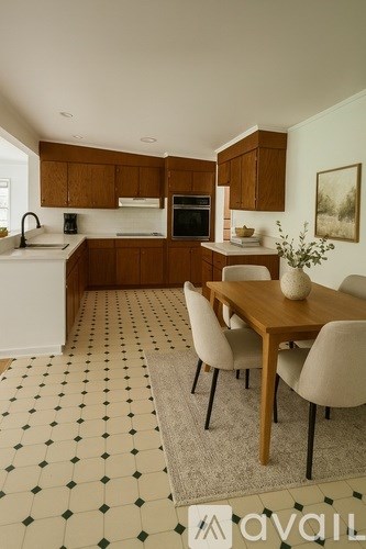 A kitchen with brown cabinets and a dining table with chairs.