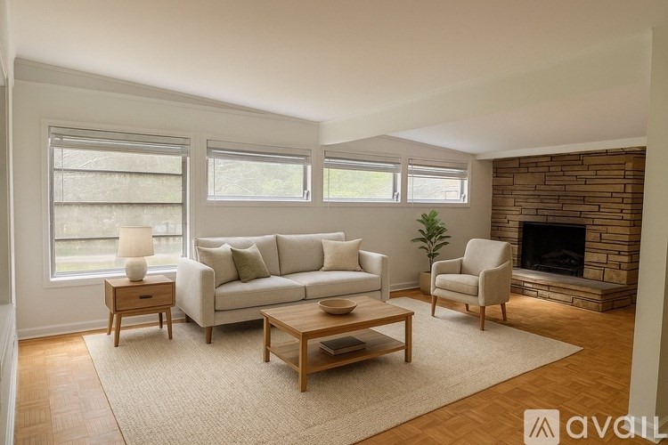 A living room with a couch, chair, and fireplace.