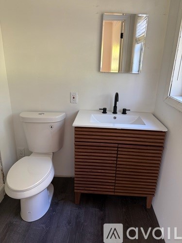 A white toilet and sink in a bathroom.