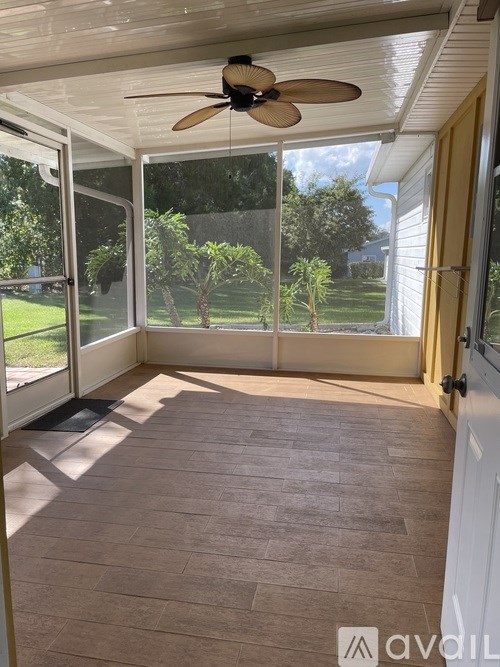 A patio with a ceiling fan and sliding glass doors.