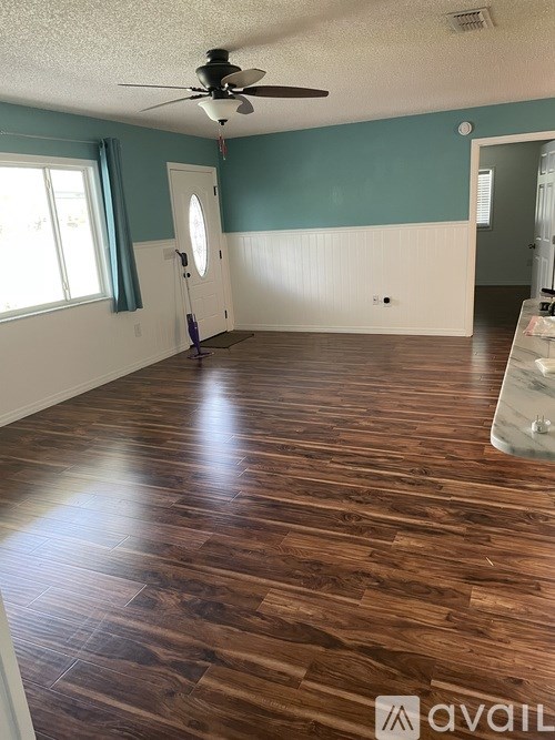 A room with wooden flooring and a ceiling fan.