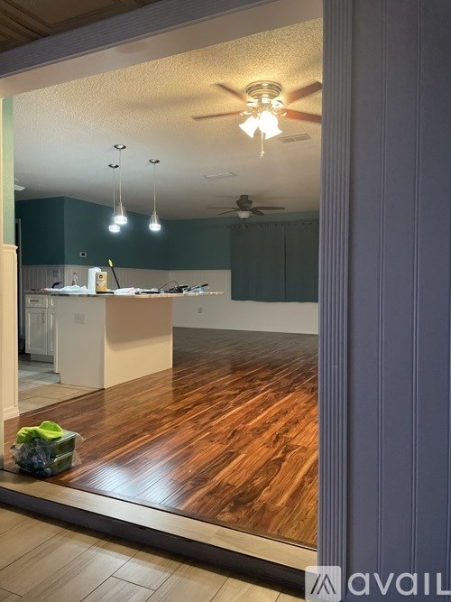 A room with wooden floors and a ceiling fan.