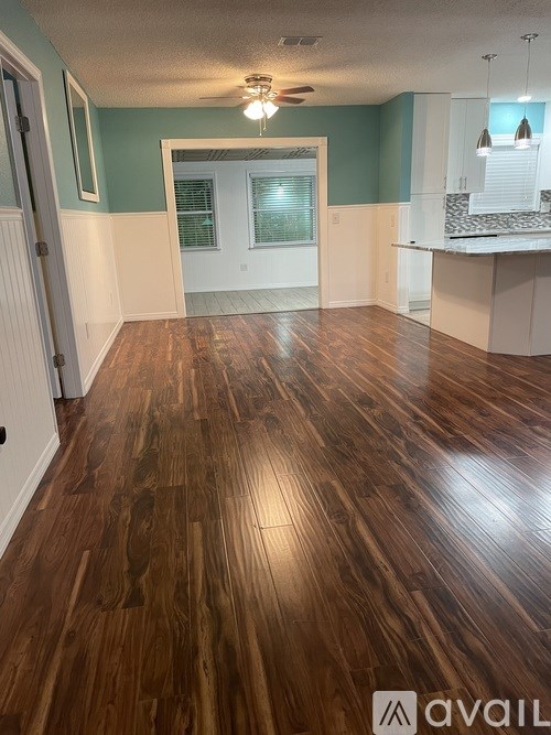 A room with wooden flooring and a window.