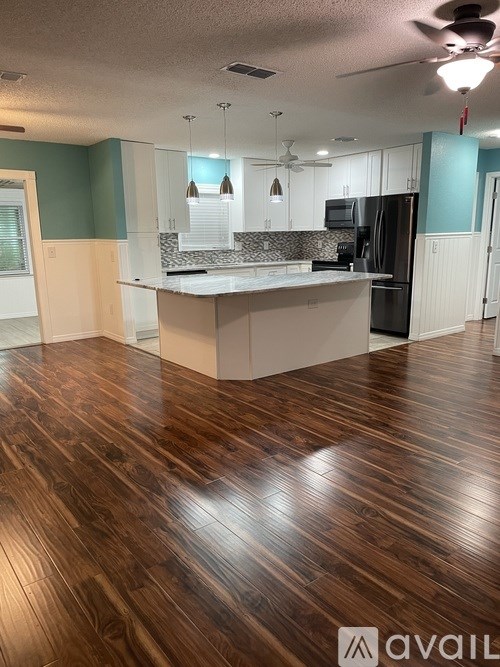 A kitchen with a wooden floor and a counter.