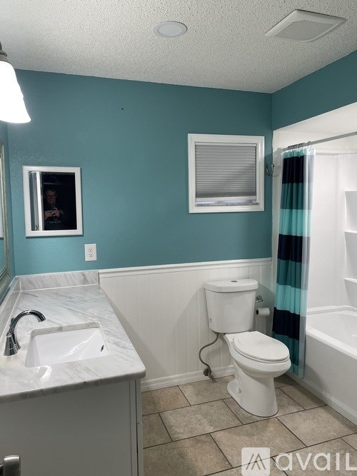 A bathroom with a white toilet and a marble sink.