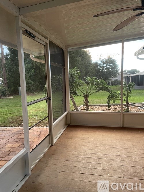 A patio with a sliding glass door leading to a backyard.