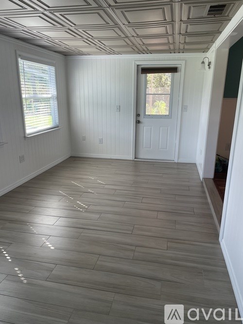 A room with wooden flooring and a white door.