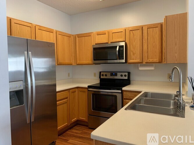 A kitchen with wooden cabinets and stainless steel appliances.