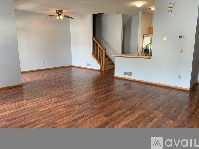 A room with wooden flooring and a staircase.