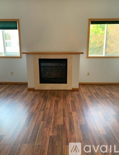 A room with a fireplace and wooden floors.