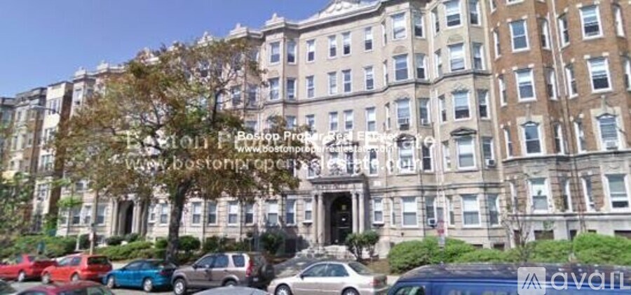 A row of brown and beige buildings with a tree in front of them.