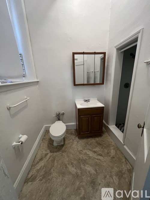 A bathroom with a toilet, sink, and mirror.