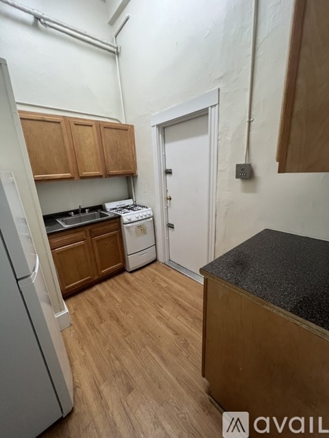 A kitchen with wooden cabinets and a black countertop.