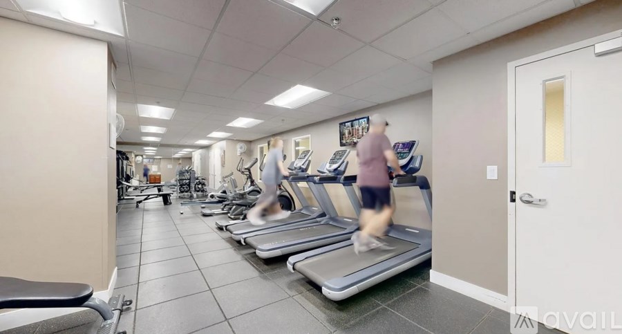 A person is running on a treadmill in a gym.