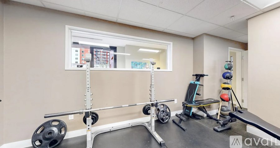A gym room with a weight rack, a bench, and a mirror.