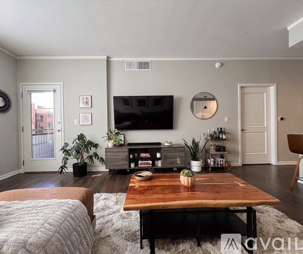 A living room with a wooden coffee table and a flat screen TV mounted on the wall.