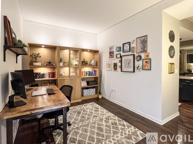 A room with a desk, chair, and bookshelves.