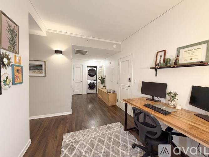 A room with a desk, chairs, and a rug.