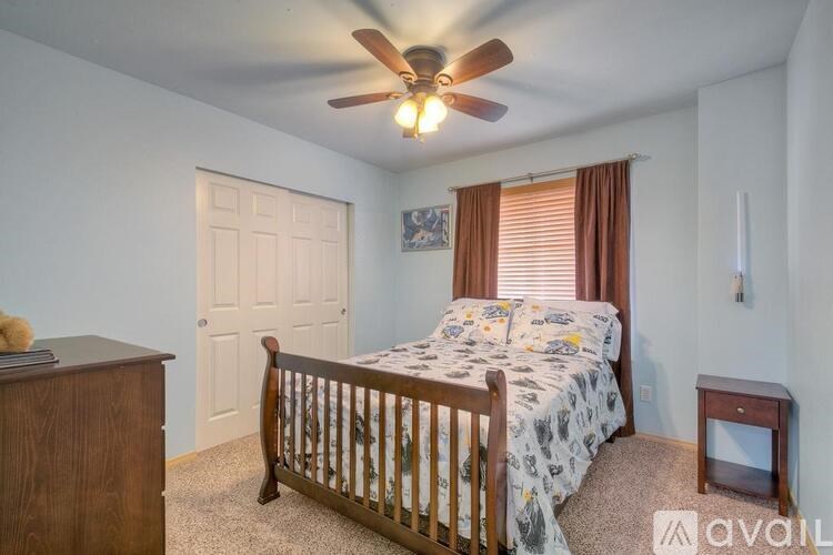 A bedroom with a bed, dresser, and window.