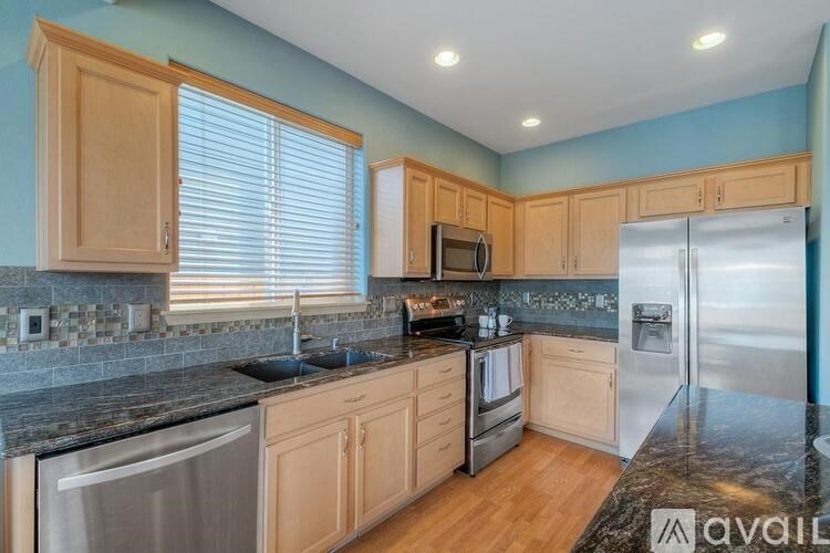 A kitchen with wooden cabinets and granite countertops.